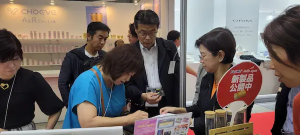 国際展示会の出展ブースで、受講生の商談に同席して助言している様子