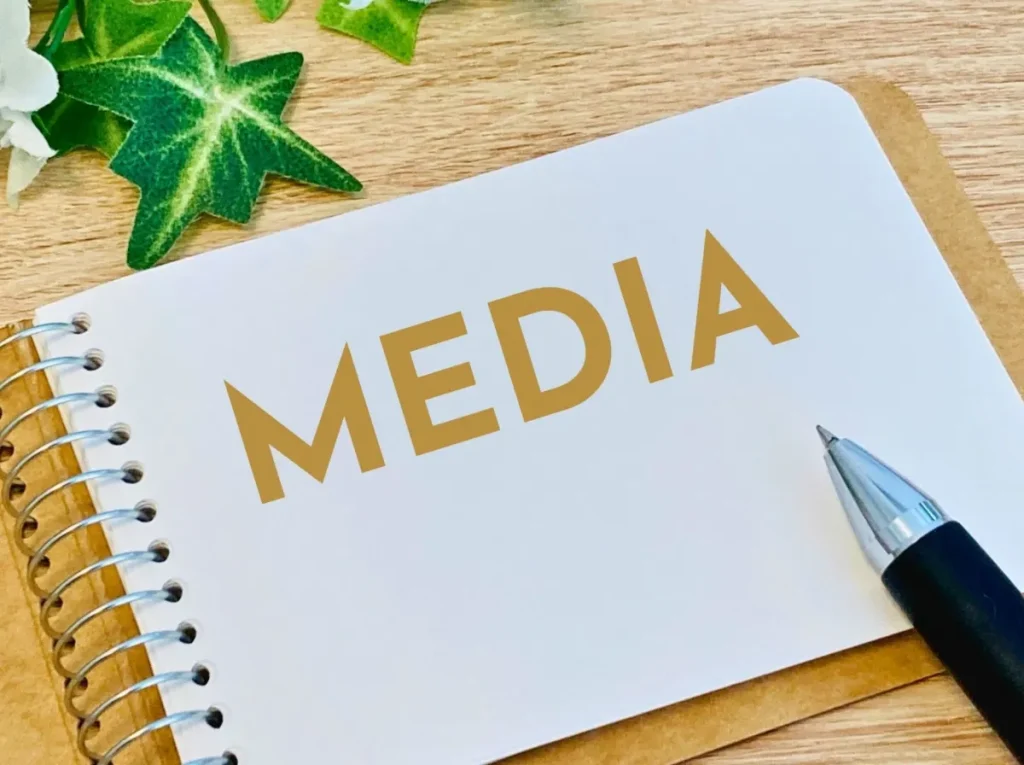 「MEDIA」と書かれたノートとペン（業界メディア対策のイメージ）